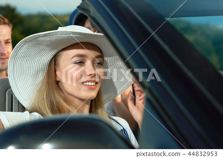 Blonde in white brim broad hat going for a drive in cabriolet. Blonde in white brim broad hat going for a drive in cabriolet. 44832953