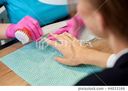 Female customer receiving professional manicure in beauty salon.  44833166