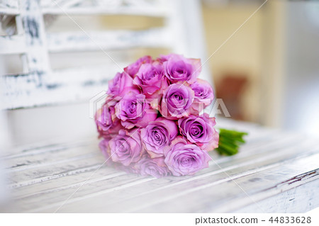 Beautiful pink bridal bouquet lying on white bench Beautiful pink bridal bouquet lying on white bench 44833628