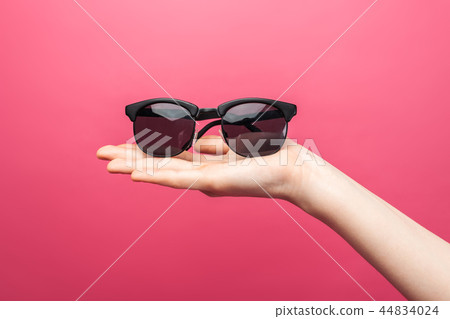 Hands holding glasses, on pink isolated Hands holding glasses, on pink isolated 44834024