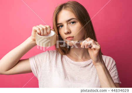 Young girl on pink background Holding  44834029