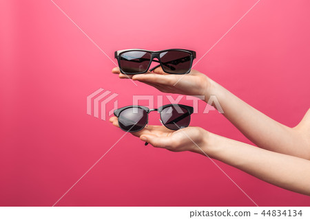 Hands holding glasses, on pink isolated 44834134