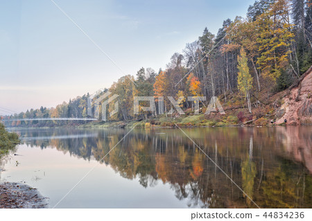 Autumn landscape and red stone cliff of Gauja river, Latvia, Europe. Autumn landscape and red stone cliff of Gauja river, Latvia, Europe. 44834236
