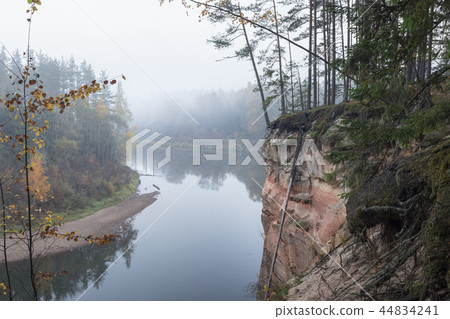 Autumn landscape and red stone cliff of Gauja river, Latvia, Europe. Autumn landscape and red stone cliff of Gauja river, Latvia, Europe. 44834241