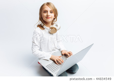 Little modern girl sitting with laptop  44834549