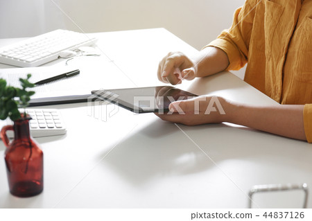 Women using tablet while working in her office. 44837126