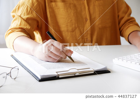 Close-up women hand while writing in office. Close-up women hand while writing in office. 44837127
