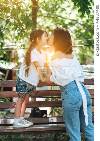 Young mother hugging her little girl in the park Young mother hugging her little girl in the park 44837489
