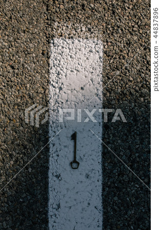 Old vintage brass door Key on asphalt road 44837896