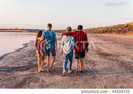 friends on beach together walking during sunset friends on beach together walking during sunset 44839750