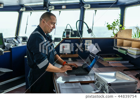 Marine navigational officer is using laptop or notebook at sea 44839754