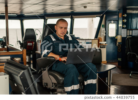 Marine navigational officer is using laptop or notebook at sea Marine navigational officer is using laptop or notebook at sea 44839755