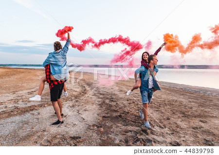 young friends running with hand flare or fusee 44839798