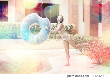 inflatable pool girl hotel girl / rest in a luxury hotel, beautiful girl in pool with an inflatable 44842999