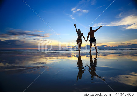 lovers run along the beach / guy and girl run along the summer sea beach, rest on the sea honeymoon 44843409
