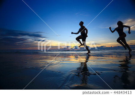 silhouettes of athletes running along the beach / sports summer in the warm sea, healthy rest, sports activity, summer vacation 44843413