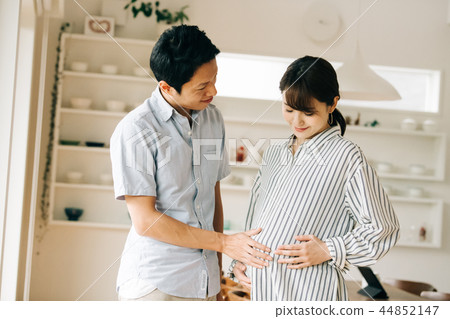 Husband checking together pregnant woman's fetal movement 44852147