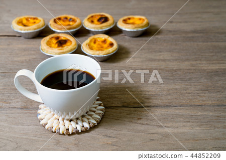 coffee with egg tart in aluminum foil cup on wood  44852209