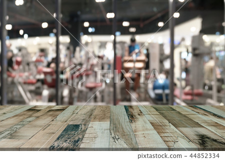 Wooden table with blur fitness gym equipment  44852334
