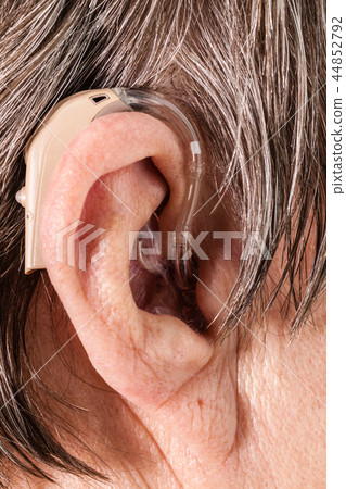 Closeup senior woman using hearing aid 44852792