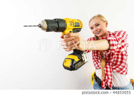 Woman using drill on wall Woman using drill on wall 44853055
