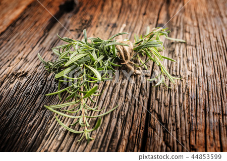 Close-up fresh rosemary on rustic oak board. 44853599