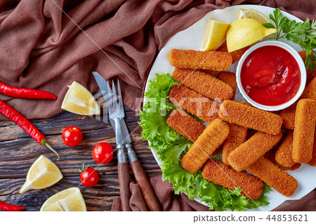 breadcrumbed fish sticks on a plate breadcrumbed fish sticks on a plate 44853621