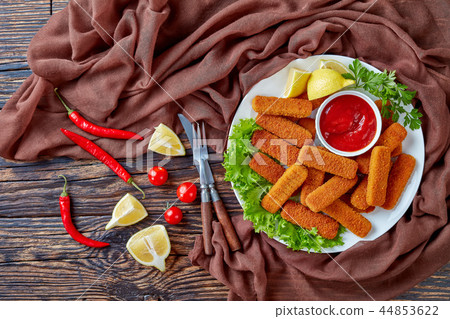 crumbed fish sticks on a plate crumbed fish sticks on a plate 44853622