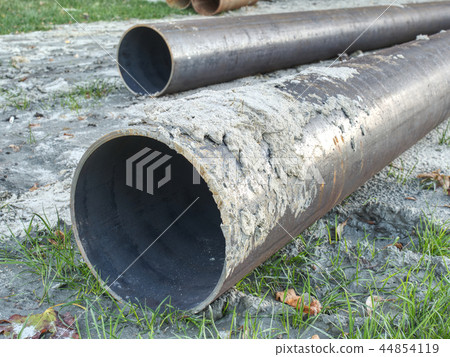 Metal pipe stack on soil. Rounded iron pipe shape 44854119