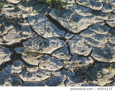 Cracks due to climate.  Dry grass turf on dry clay 44854123