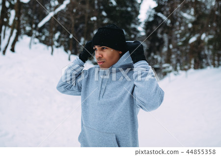 Sportsman standing in winter forest holding a hood Sportsman standing in winter forest holding a hood 44855358