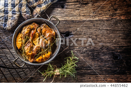 Roasted duck legs in pan with oranges and herbs. Roasted duck legs in pan with oranges and herbs. 44855462