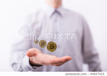 Male hand presenting levitating coins of bitcoin. Male hand presenting levitating coins of bitcoin. 44857425