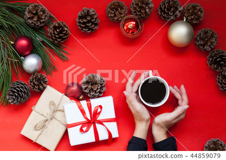 Christmas tree needles Cup of tea in the hands of the Red Christmas background Christmas 44859079