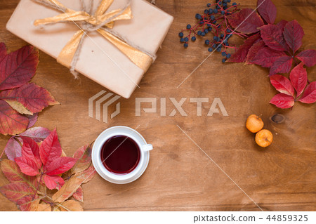 Autumn leaves a cup of tea and coffee gift on wooden background Autumn leaves a cup of tea and coffee gift on wooden background 44859325