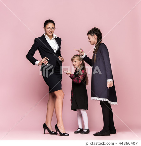 Cute stylish children on pink studio background. The beautiful teen girls standing together Cute stylish children on pink studio background. The beautiful teen girls standing together 44860407