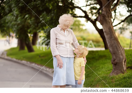 Granny and her grandchild walking together in park Granny and her grandchild walking together in park 44868639