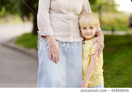 Granny and her grandchild walking together in park Granny and her grandchild walking together in park 44868640