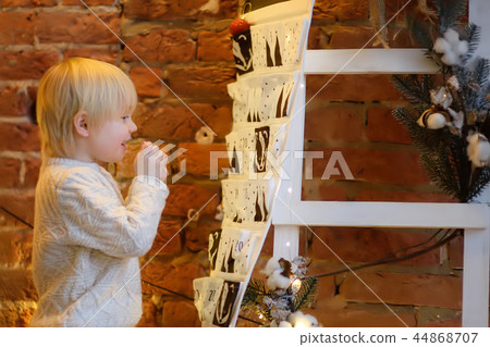 Boy takes sweet from advent calendar in Christmas 44868707