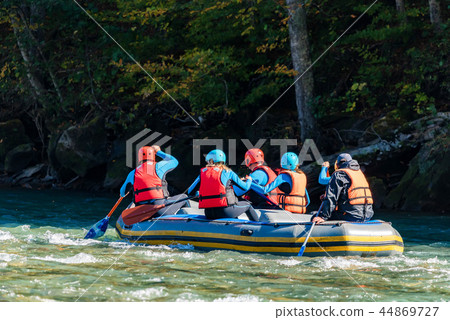 Group of young people going white water rafting Group of young people going white water rafting 44869727