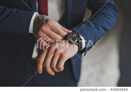 The man checks the time on the wristwatch 1584. The man checks the time on the wristwatch 1584. 44869984