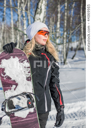 Young adult woman snowboarder holding snow board Young adult woman snowboarder holding snow board 44869985