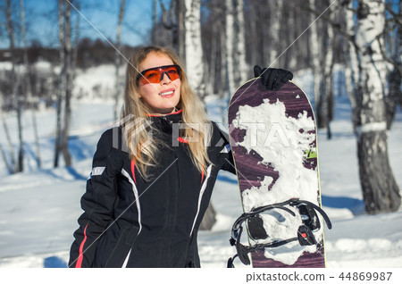 Young adult woman snowboarder holding snow board Young adult woman snowboarder holding snow board 44869987
