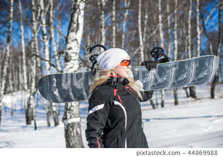 Young adult woman snowboarder holding snow board 44869988
