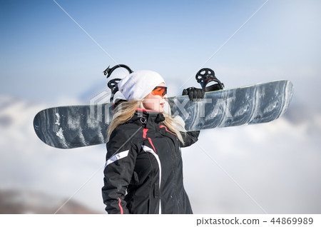Young adult woman snowboarder holding snow board 44869989