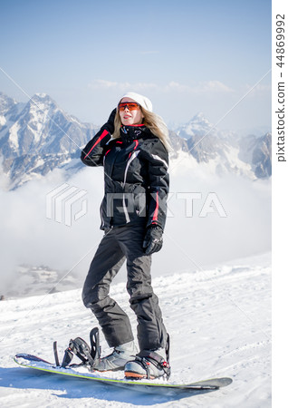 Young adult woman snowboarder holding snow board Young adult woman snowboarder holding snow board 44869992