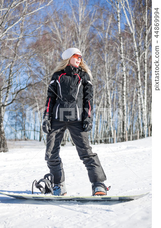 Young adult woman snowboarder standing on board 44869994