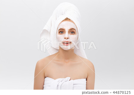 Close-up beautiful woman applying moisturizer cosmetic cream on face on light background. Close-up beautiful woman applying moisturizer cosmetic cream on face on light background. 44870125