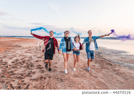 young friends running with hand flare or fusee young friends running with hand flare or fusee 44870526