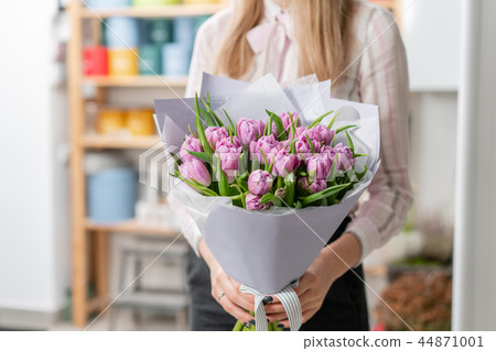 Sunny spring morning. Young happy woman holding a beautiful bunch of lilac tulips in her hands Sunny spring morning. Young happy woman holding a beautiful bunch of lilac tulips in her hands 44871001